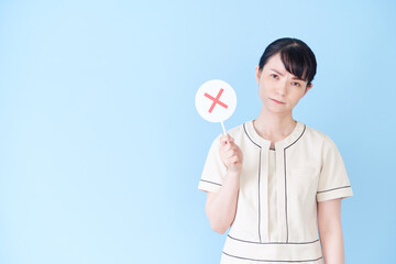 マルバツの棒を持つエステ・美容クリニックの女性