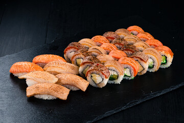 Traditional Japanese cuisine nigiri and sushi rolls with tuna, salmon, eel, tobiko caviar, cream cheese, avocado, mango and chuka seaweed.