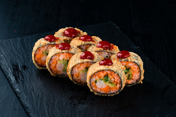 Set of maki tempura sushi rolls with shrimp, avocado, cucumber, tobiko caviar and red sauce.