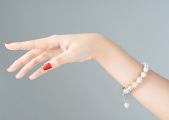 Pearl bracelet on a hand,Image of beautiful nails and woman fingers.