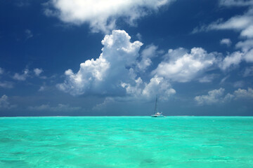 Sailing yacht in turquoise ocean at anchor off the beautiful tropical island of Bora Bora, French...