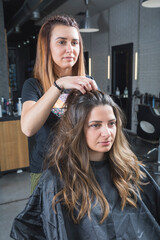 Naklejka premium hairdresser and beautician working in her hair salon