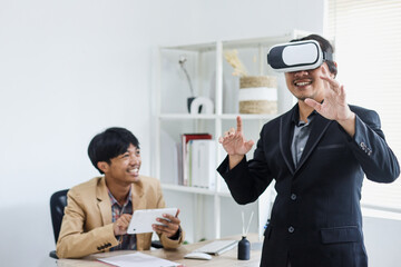 Excited two workers having  simulation using VR glasses and tablet smartphone at the office. 