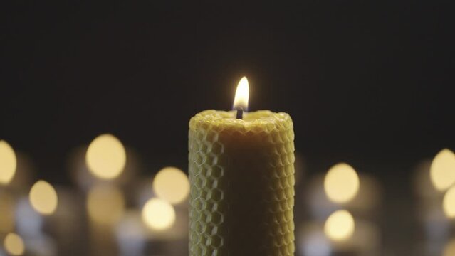 Many candles burn in the dark. Beautiful background video of a romantic atmosphere. Light in the darkness flickering candles.