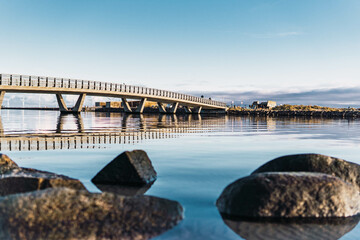 Fototapeta premium river landscape and people passing through the bridge