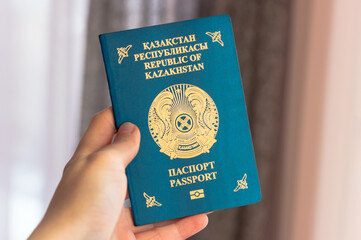 Person holds Kazakhstan travel passport in hand. Travel, tourism or immigration concept. Kazakhstan...