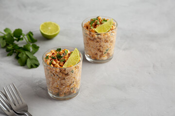 Homemade Mexican Corn Elote Esquites in Cups, side view. Copy space.
