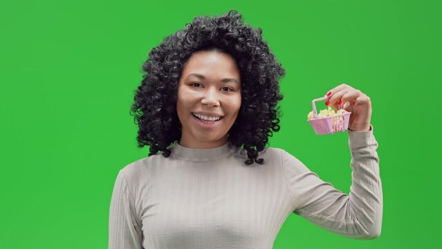 young woman showing pink shopping cart happy smiling satisfied customer posing isolated green background