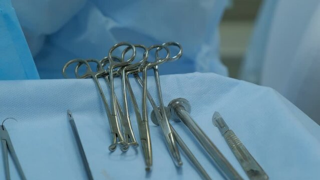 On the table are a set of disinfected metal tools for surgery. Close-up.