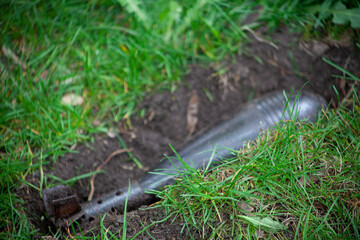 Rocket bomb lies buried in the green grass. Weapons of mass destruction. Old projectile. Mine of mass destruction on the ground. Outdoor.