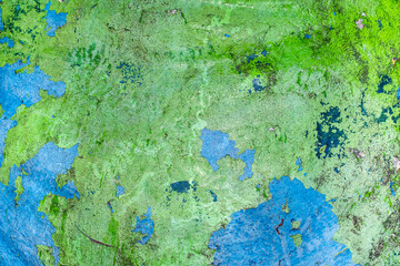 Green and blue concrete wall with cracks and chipping texture
