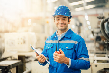 Professional Engineering of modern factory checking  to automatic machinery. Engineering with clipboard Programmable Logic Controller to manage large machine working full automatic.