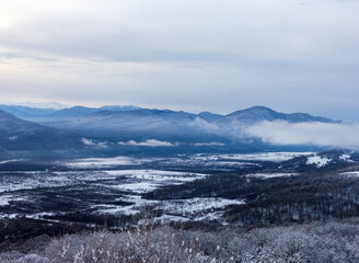 A winter morning in a mountainous area, a panorama of snow-capped mountains, slopes in a snowy decoration.