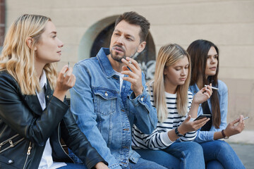 People smoking cigarettes at public place outdoors