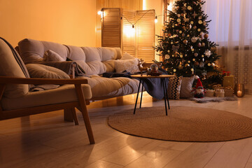Beautiful room with sofa and tree decorated for Christmas. Interior design