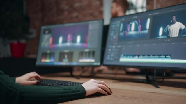 post-production and processing video by computer, closeup view of two display and hands woman editor