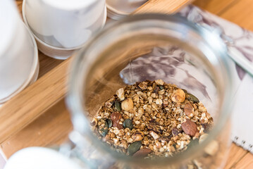 Healthy granola for breakfast in jar on brown table - 568738356