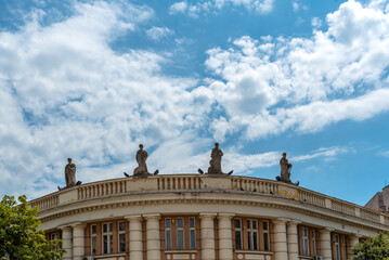 Historic building with several statue on the top with cloudy sky - 568738500
