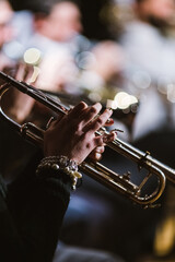 Focus on the hands of a trumpet player during a concert in a theatre