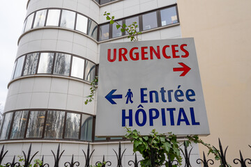 Enseigne avec "URGENCES" écrit en rouge et "Entrée Hôpital" en bleu indiquant respectivement la direction du service des urgences et l'entrée d'un hôpital en France