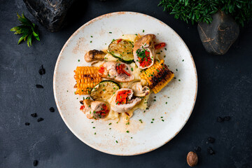 Chicken rolls with baked peppers, mashed potatoes, zucchini slices, corn and herbs.