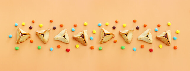 Purim celebration concept (jewish carnival holiday). Hamantaschen cookies over yellow background
