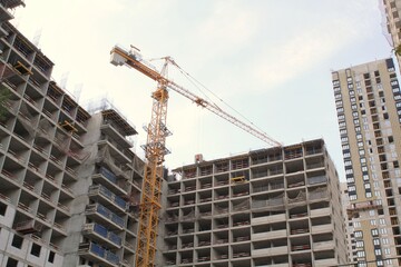 Fototapeta na wymiar Crane and building construction site. Industry modern new civil house business. Concept of development improvement town. Architecture planning of a city. Renovation project. Residential area