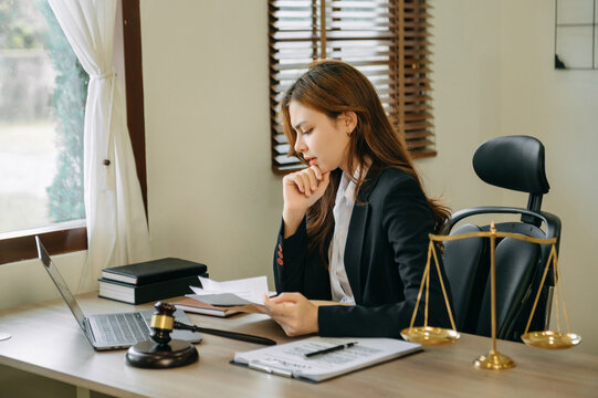 .Asian lawyer woman working with a laptop and tablet in a law office. Legal and legal service concept.