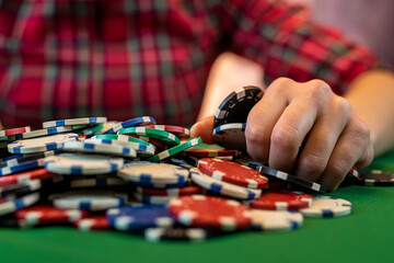 Naklejka premium woman in a casino with many chips that she wraps up after a big win in poker.