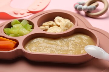 Healthy baby food. Section plate with delicious apple puree, vegetables and fruit on pink background, closeup