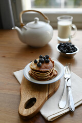 delicious homemade pancakes with blueberries on wooden background