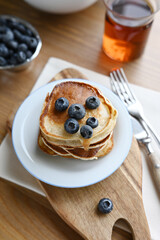 delicious homemade pancakes with blueberries on wooden background