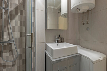 Bathroom interior with glass shower cabin in rental apartment