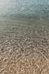 Pure clear transparent calm water surface background of sea or ocean with sandy bottom for wallpapers. Traveling to south. Spending summer vacations in warm mild climate. No people