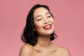 Beauty model woman with brown hair and red lipstick laughing at studio