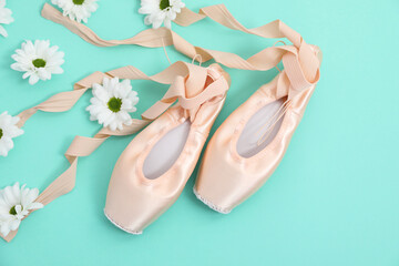 Fototapeta na wymiar Ballet shoes. Elegant pointes and flowers on turquoise background, flat lay