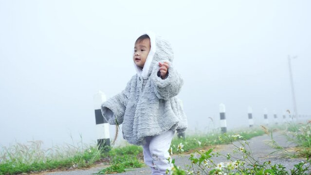 4K, cute little girl, wearing thick sleeveless shirt hat and pants, alleviate cold morning fog, parents let she take walk enjoying nature around he, little girl has happy expression.