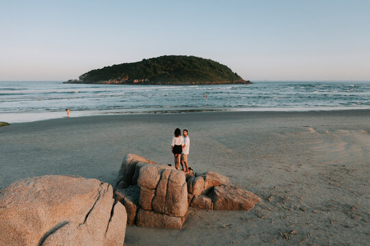 Ein P&auml;rchen steht am Strand. Im Hintergrund sieht man die Insel Ilha do Batuta. Santa Catarina