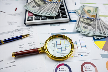business concept investment chart reports with magnifying glass and calculator  on desk