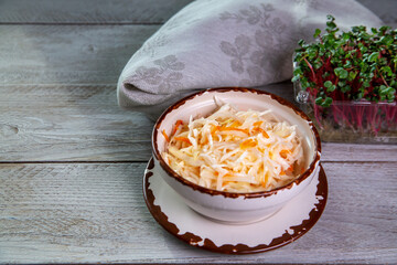 Sauerkraut in a bowl on a wooden table. Fermented food. Healthy food, vitamins, fiber.