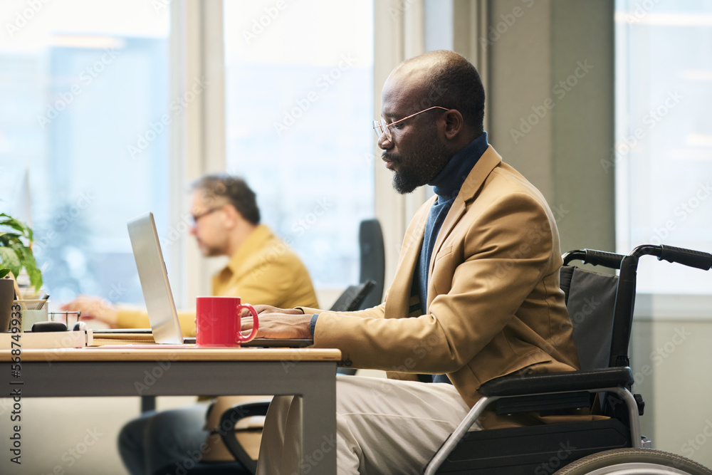 Poster side view of young african american businessman with disability networking by desk in coworking spac
