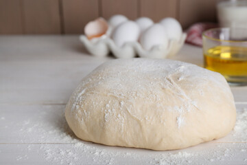 Fototapeta na wymiar Fresh yeast dough with flour on white wooden table, closeup. Space for text