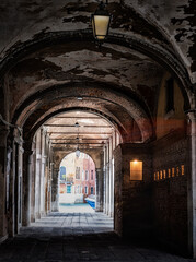 Fototapeta na wymiar View Through An Arched Walkway To One Of Canals In Venice