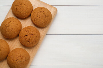 Delicious oatmeal cookies on white wooden table, top view. Space for text