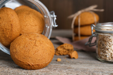 Delicious oatmeal cookies and flakes on wooden table, closeup. Space for text
