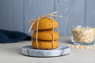 Delicious oatmeal cookies tied with twine on white table