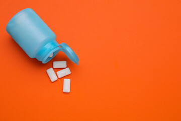 Jar with chewing gums on orange background, flat lay. Space for text - obrazy, fototapety, plakaty