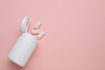 Jar with chewing gums on light pink background, flat lay. Space for text