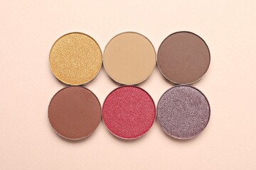 Beautiful eye shadow refill pans on beige background, flat lay