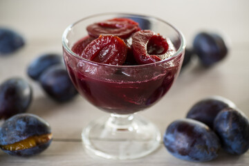 Sweet plums in syrup, in a glass bowl .